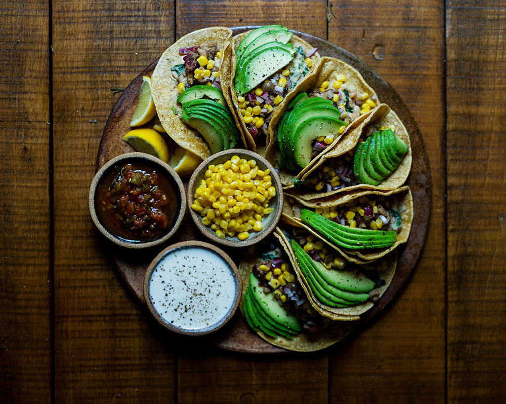 Tacos with corn, avocado, and various sauces