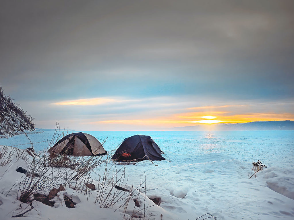 Two tents near a frozen lake