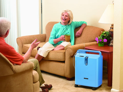 Woman sitting next to an oxygen concentrator