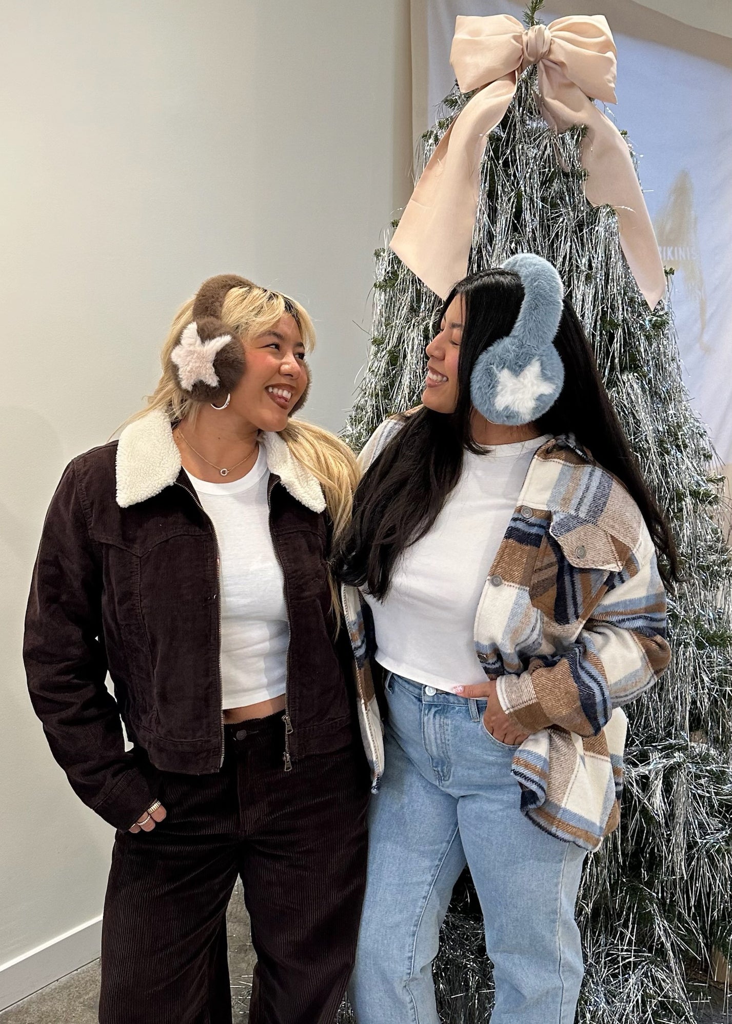 models smiling while wearing Sugar Muffs in front of Christmas tree