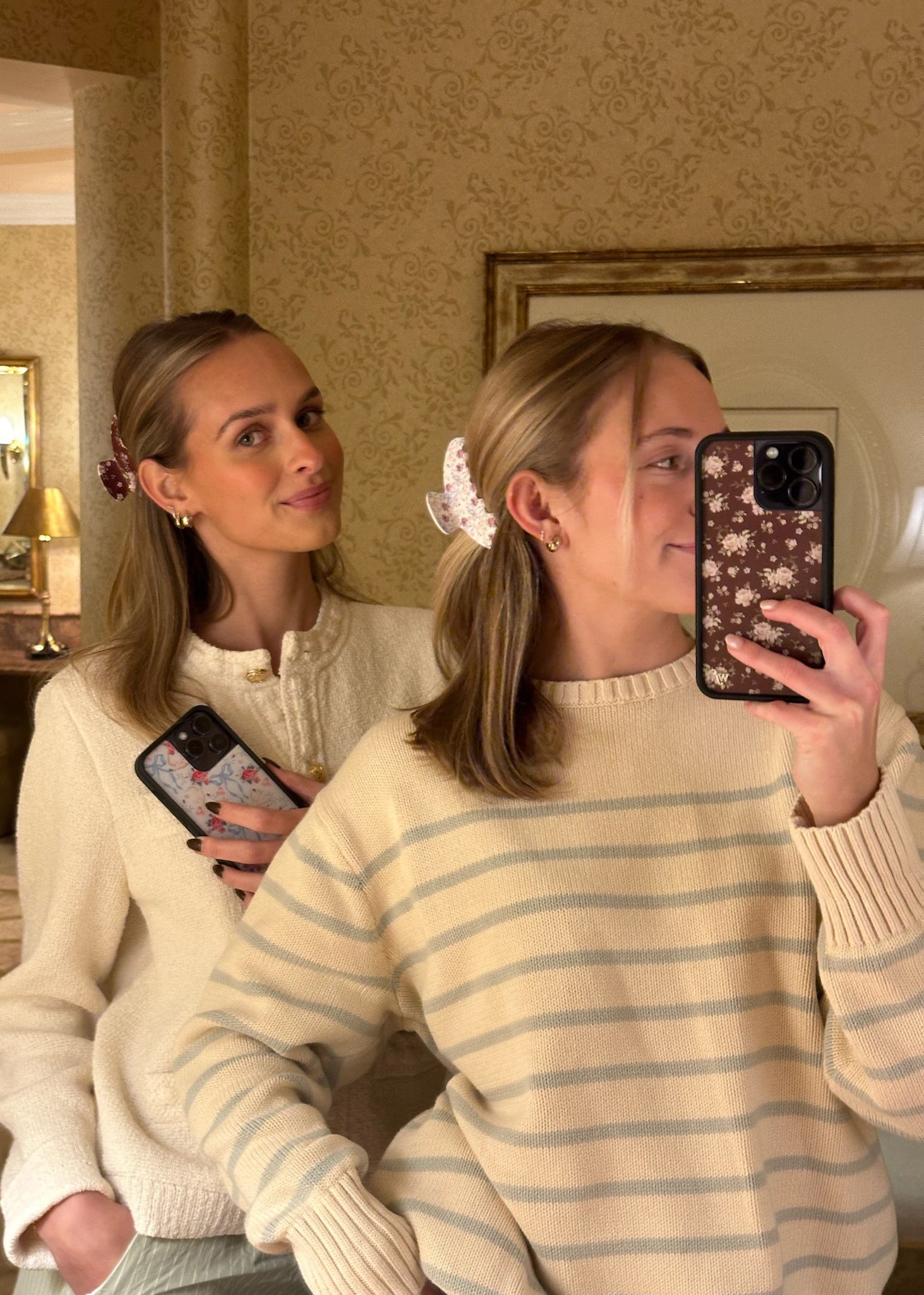 models taking selfie while wearing Emi Jay x Wildflower Big Effing Clips in hair and holding phones with matching Wildflower Cases