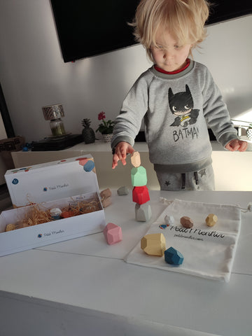 Child playing with the wooden educational building set Petit Menhir