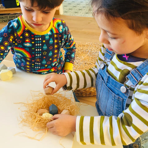 Children playing with the wooden educational game Petit Menhir