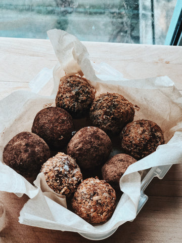 date and tahini energy balls in a baking tray with wax paper