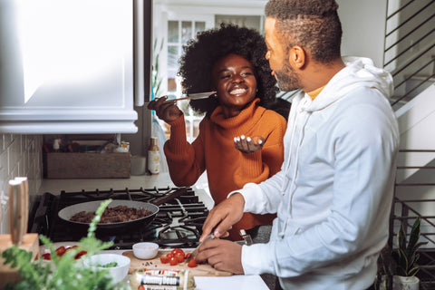 Man en vrouw kokend in de keuken