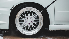 A man power washing his car tyres