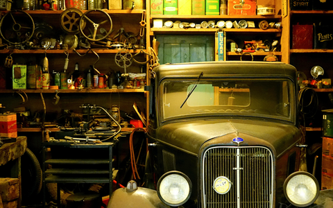 A car in a garage with car detailing products visible in the background.