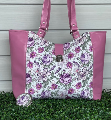 a large size tote bag with a floral centre and pink leather side accents.