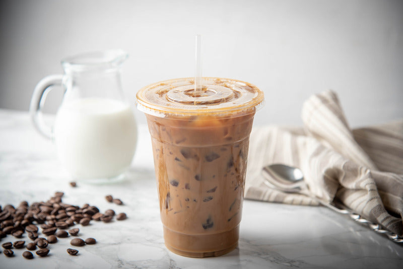 Large disposable cup with lid and straw, perfect for iced coffee on-the-go.