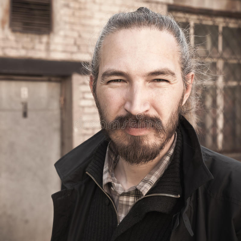 closeup-square-portrait-young-bearded-asian-man-outdoor-black-grungy-building-background-vintage-stylized-photo-warm-71498215