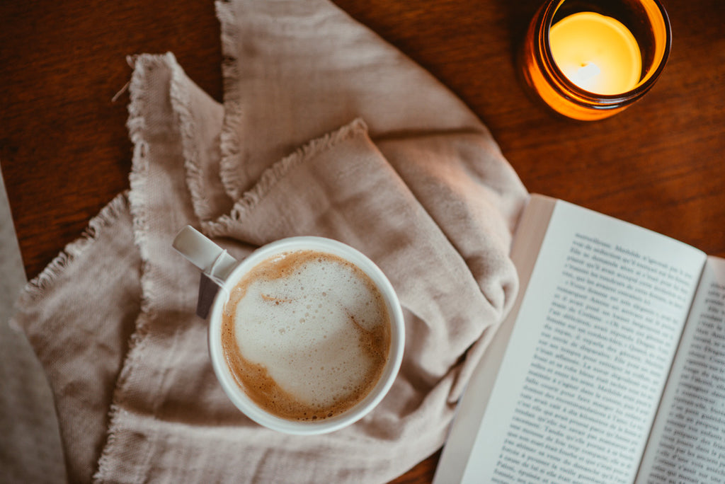 chai latté avec une chandelle et un livre 