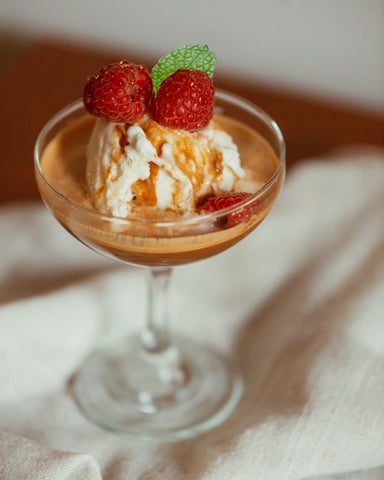 espresso sur boule de crème glacée à la vanille avec framboise et menthe dans une coupe de verre