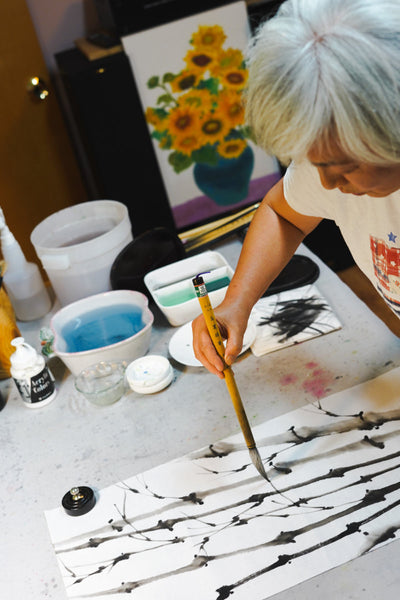 Yeoshin working in a studio on a bamboo painting with rice paper and India ink