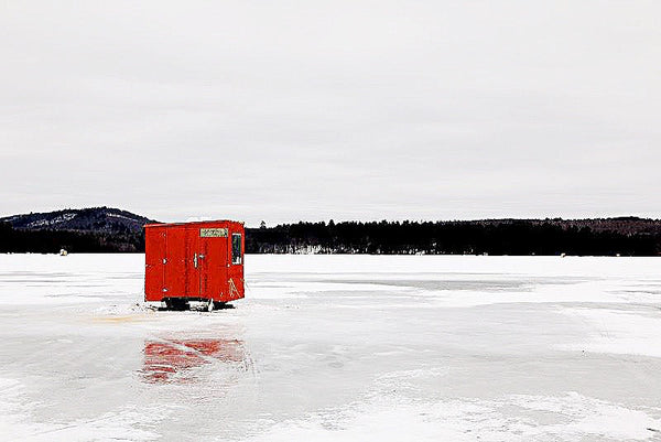 Frozen lake with red fishing house in Maine 