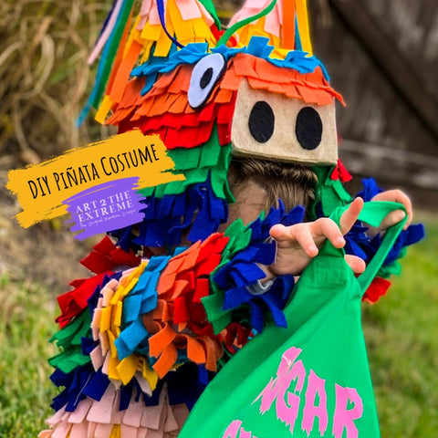 DIY Pinta Costume tutorial for kids halloween costume. Image of child wearing a rainbow colored pinata costume looking in a green halloween treat bag.