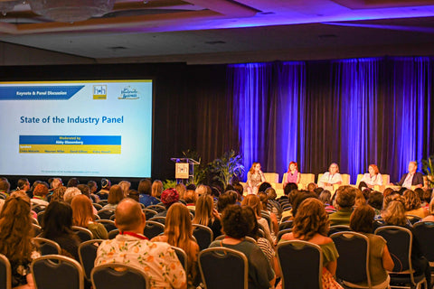 h+h americas conference session about The State of the Craft Industry with Craft Industry Alliance. Image shows people sitting, facing a stage with a panel of 5 people in chairs.