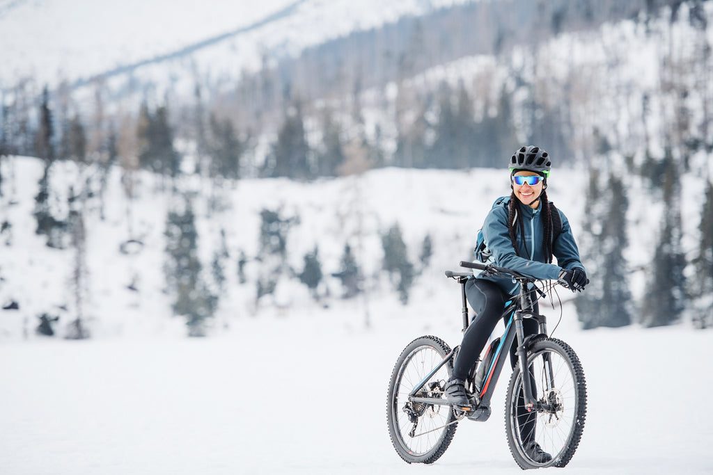 Frau fährt durch die verschneiten Berge und dank einer guten Jacke wird der Frau nicht kalt