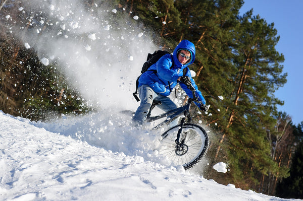 Mann fährt im Schnee MTB