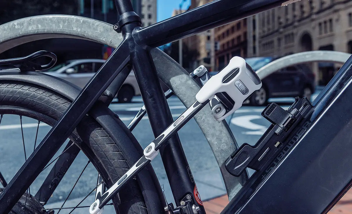 Faltschloss von der Marke Abus an einem Fahrrad und einem Haltebügel