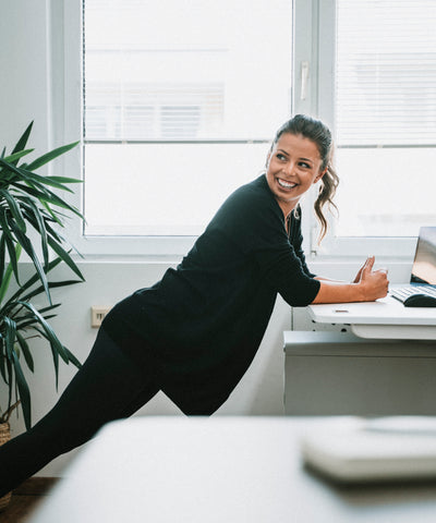 Frau macht einfache Körperübung im Büro.