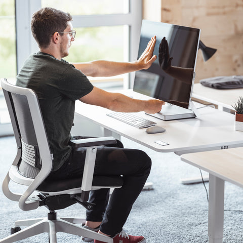 Man arbeitet an einem Schreibtisch mit der richtigen Schreibtisch-Tiefe.