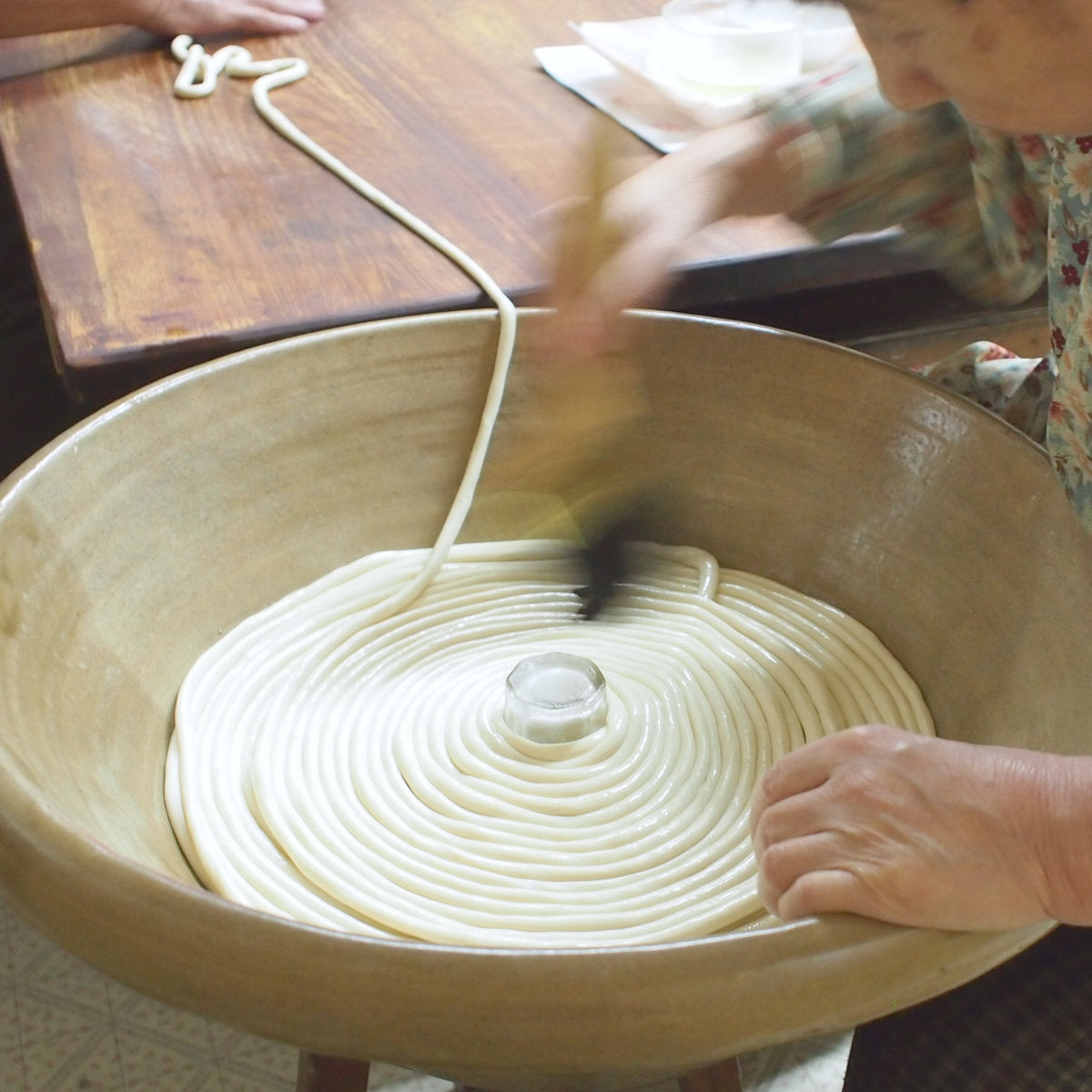 乾燥を防ぐ油を塗りながら工程を重ねる製麺の作業