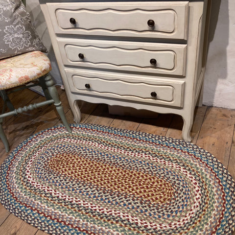 neutral, cool toned chest of drawers with Carnival braided rug