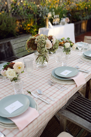 tablescape with green dishes and flowers on the table.