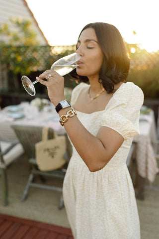woman drinking champagne in a yellow printed dress