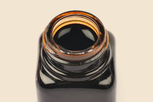 a clear bottle with pure shilajit resin inside of it viewed from the top