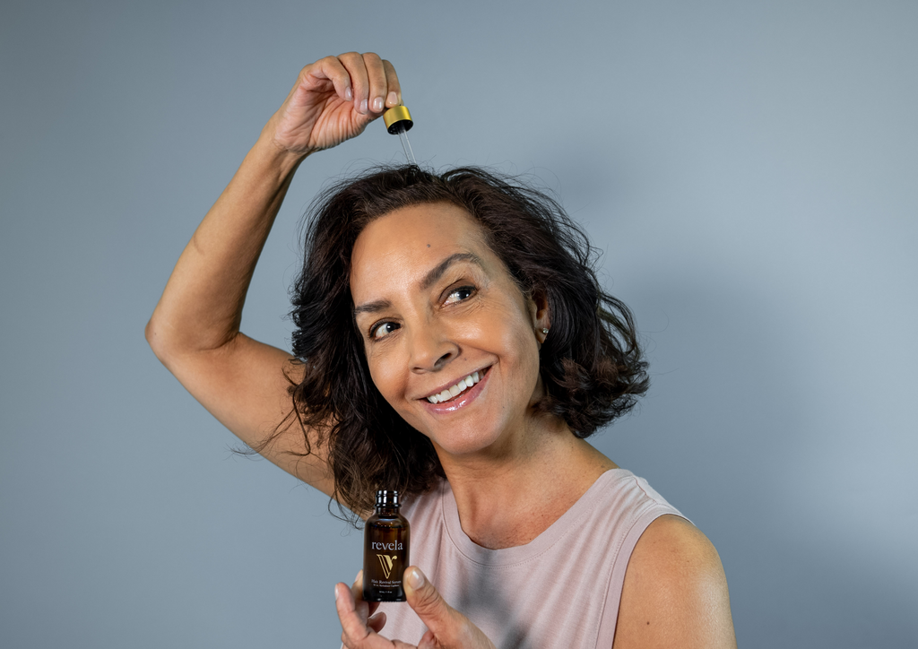 Woman applying dropperful of serum to head