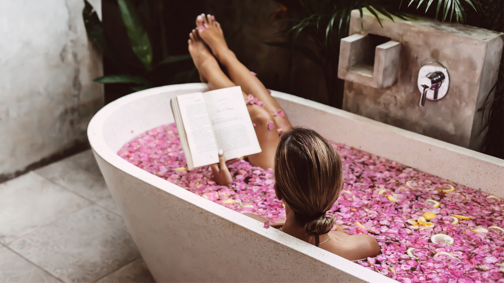 Relaxen mit einem Buch in der Badewanne Öl einziehen lassen.