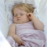 sleeping outside in her dusty rose organic merino vest and swaddle blanket from roots & wings organic merino