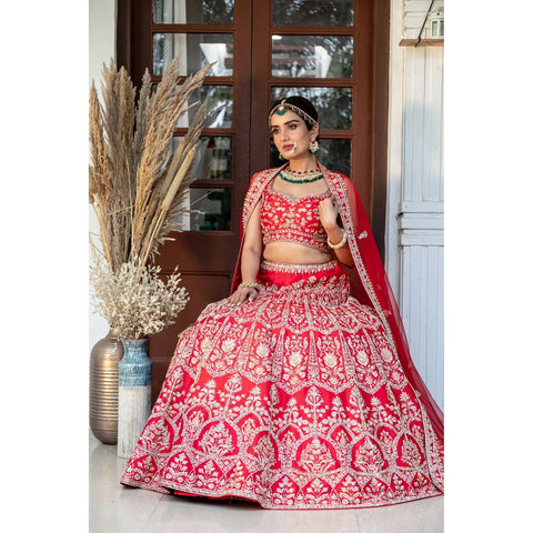 Venetian red silk bridal lehenga choli embroidered with persian floral arch motifs in zardozi, resham and beads; paired with a red net dupatta with embroidered buttis and border.