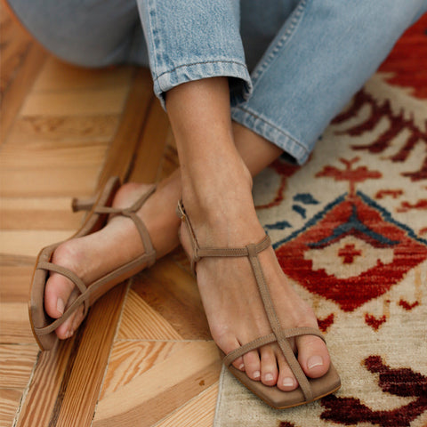 Primer plano de piernas femeninas en zapatos beige sin tacones