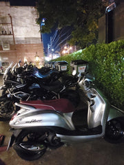 motorcycles with one scooter parked at night