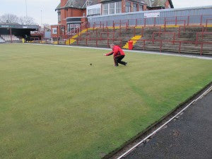 Mark Audin checking the progress of the wood over the green drainage line visible