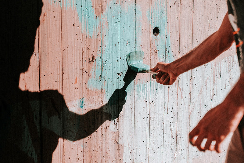 A fence being painted blue