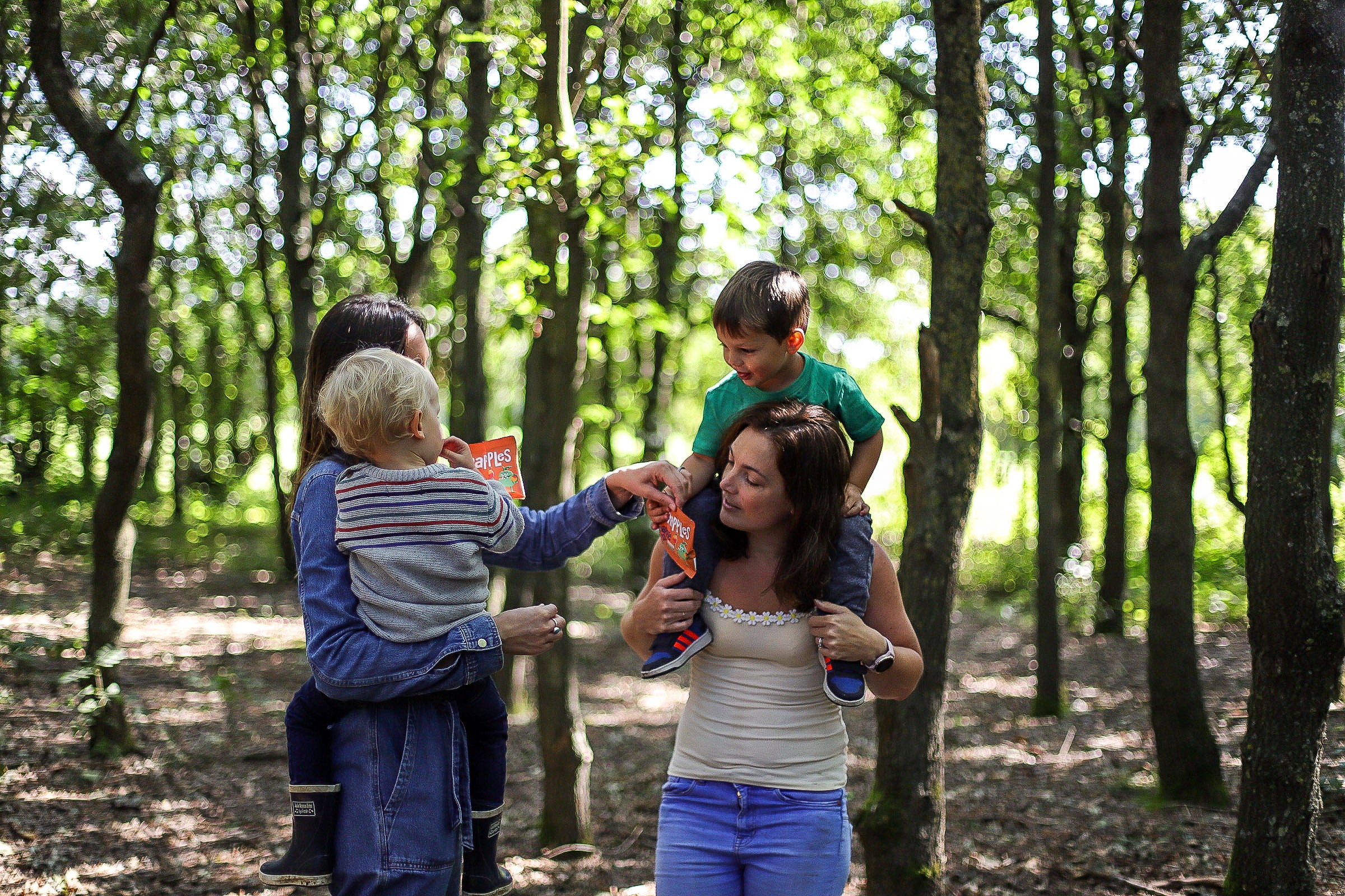 Family of 4 in a forest sharing a bag of Scrapples