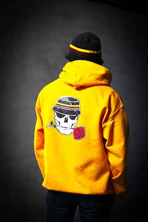Picture of a yellow hoodie with a skull and rose on it. 