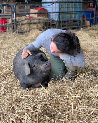 Isabel kneeling with one of her pigs