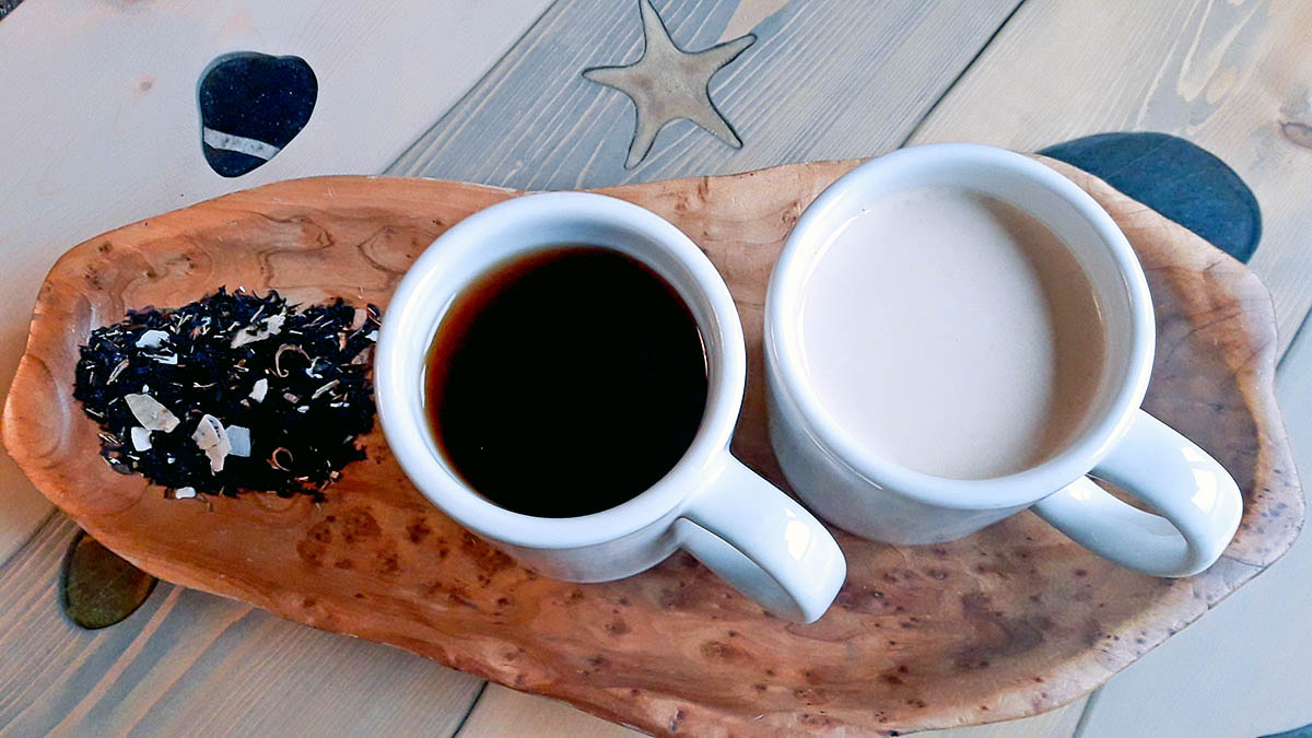Caramel tea, in both milk and no milk forms, accompanied by loose-leaf tea on a wooden tray.