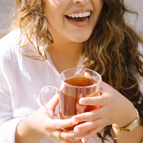 woman smiling with a mug of tea