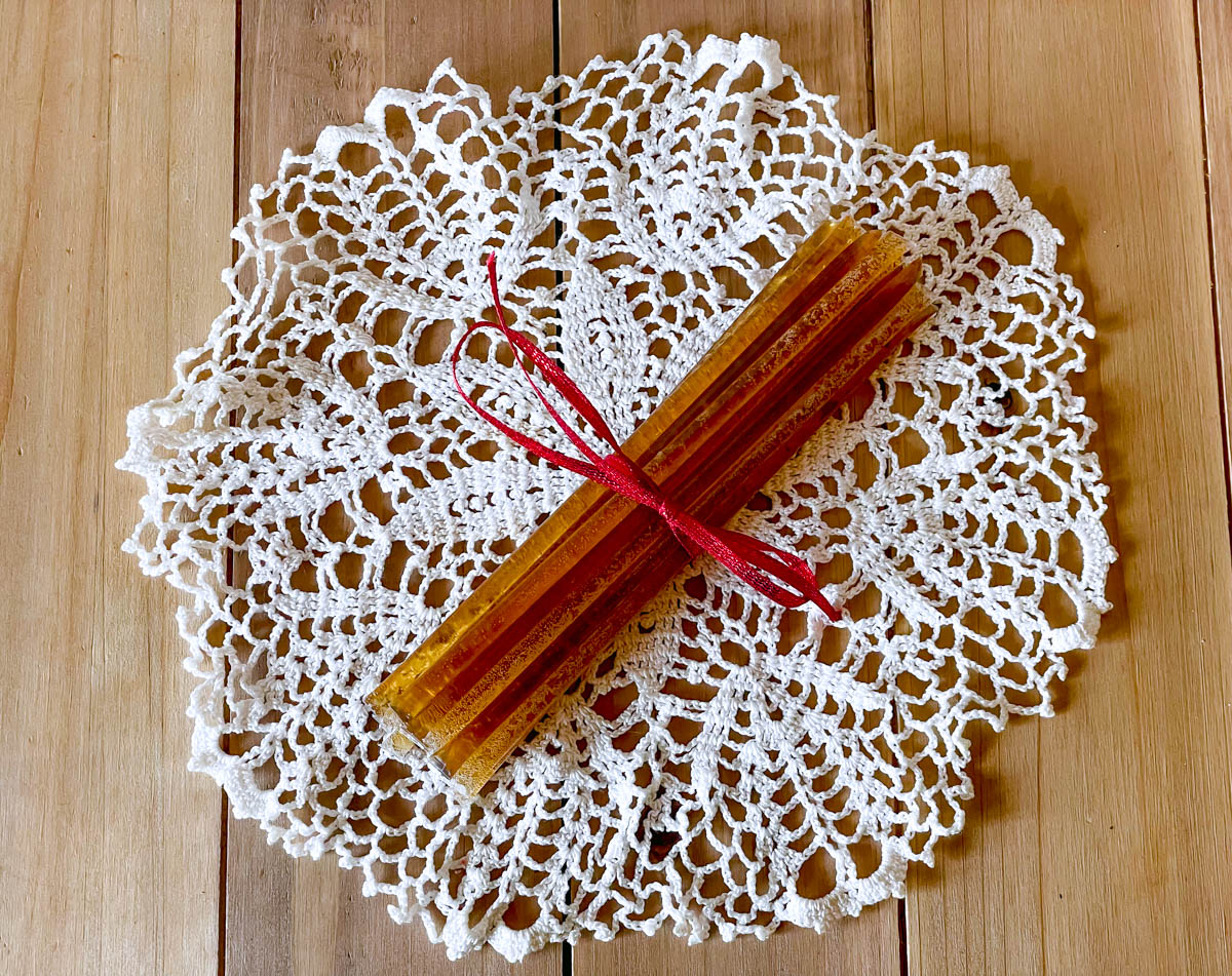 A bundle of honey sticks tied up with red ribbon to be used as a gift or decoration.