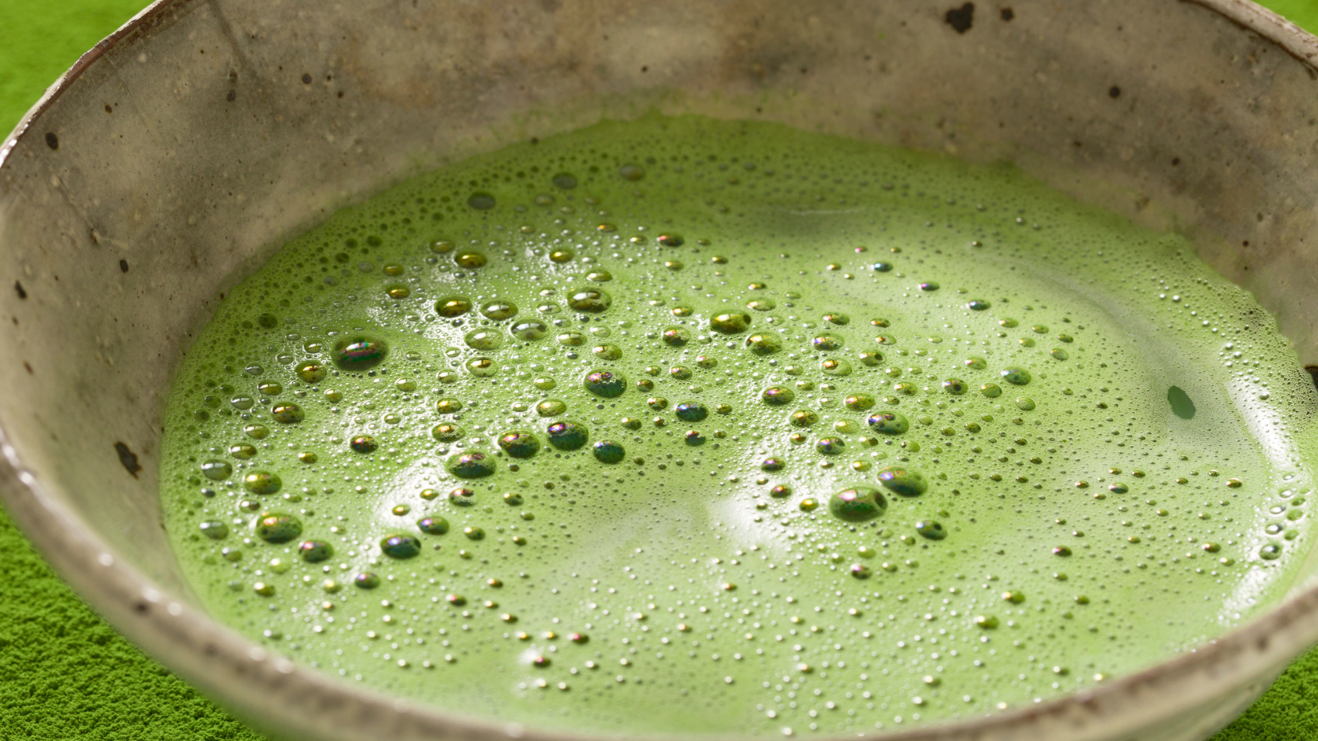 Bowl of matcha green tea with a frothy surface