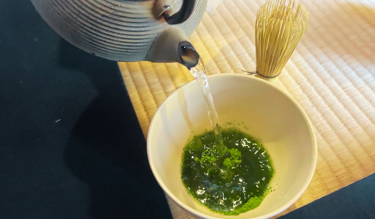 Una ceremonia japonesa en la que el anfitrión vierte agua caliente sobre el polvo de matcha en un cuenco chawan.