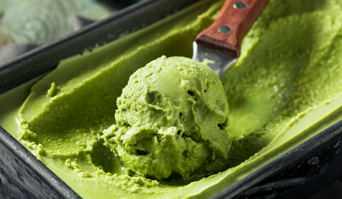 Tub of matcha ice cream with an icream scoop