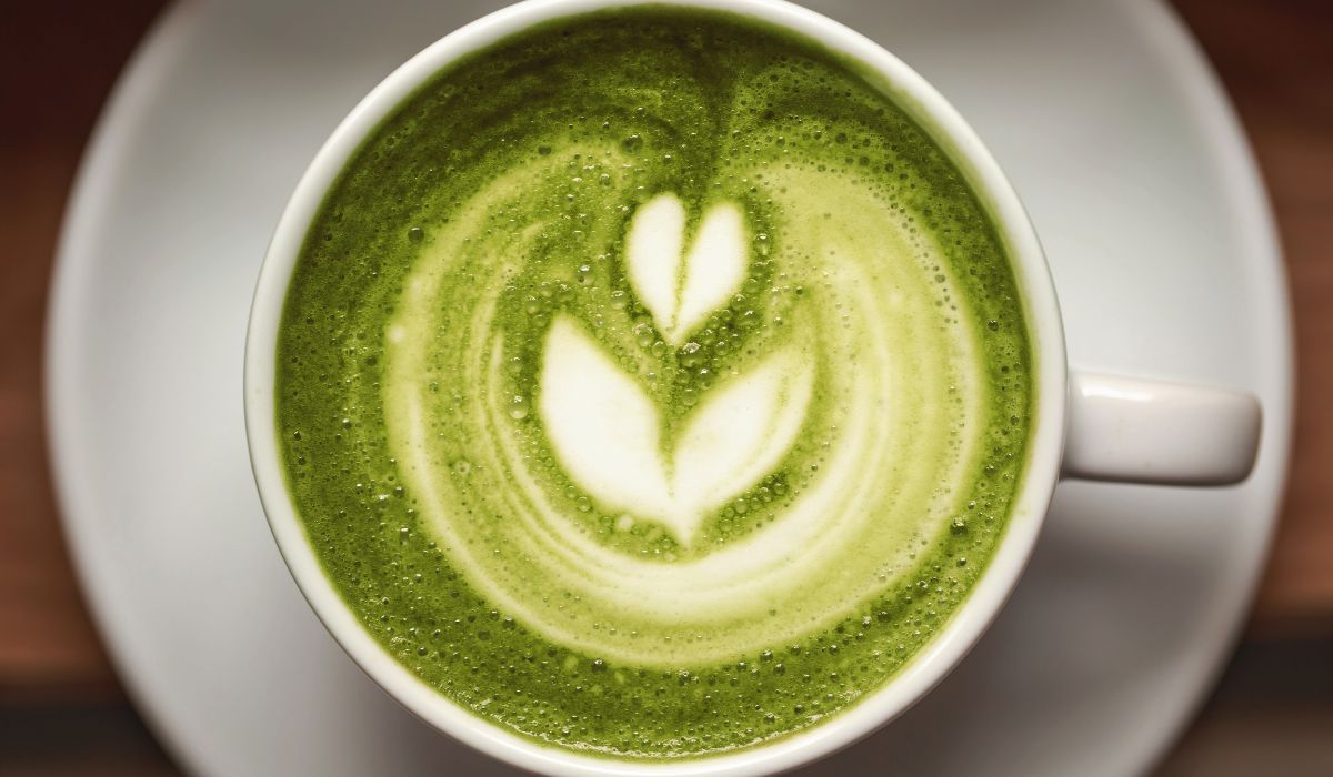 Bright green matcha latte with the froth in the shape of a leaf
