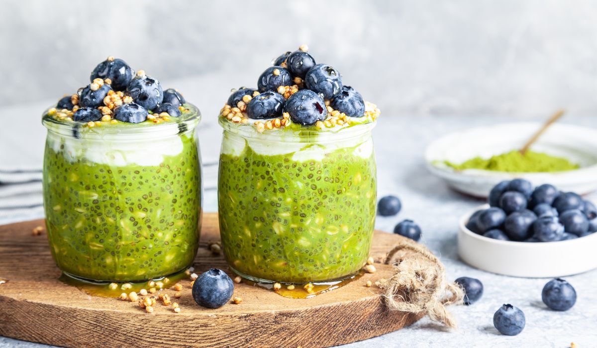 Two glass jars of matcha overnight oats with chia seeds and blueberries