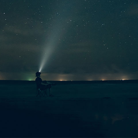 man watching the sky at night in a flat land